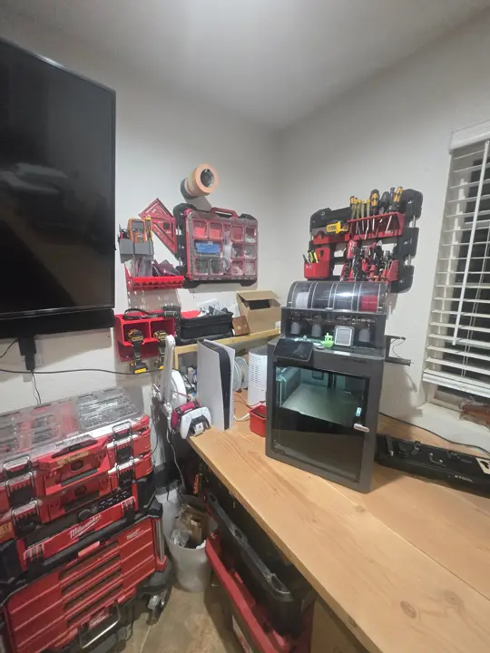 Bambu Lab X2D with AMS 2 under the PACKOUT wall